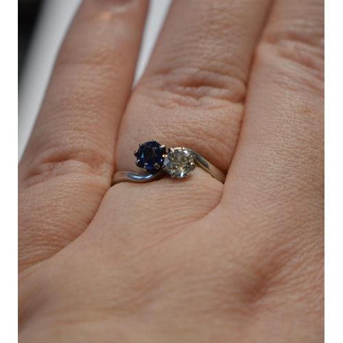 172 - Diamond and sapphire cross-over two-stone ring, the brilliant approximately .5ct, white gold and pla... 