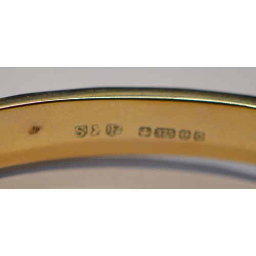 199 - 9ct gold lady's bangle, stamped '375', with attached safety chain, 6.5cm diameter, 10.3g gross.