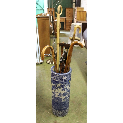 550 - Oriental blue and white stick stand containing walking sticks.