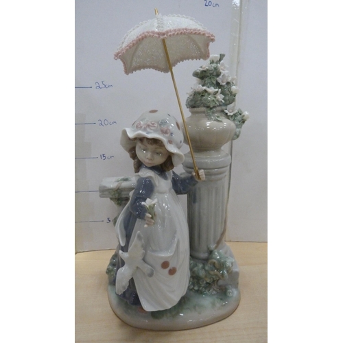 101 - Pair of Lladro bookends in the form of a girl holding a parasol and a girl sweeping with a kitten ne... 