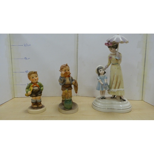 105 - Collection of Goebel Hummel figures, two Hummel table lamps, and a mother and child group.