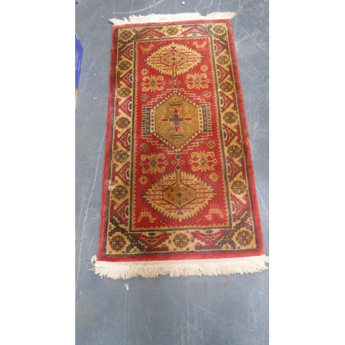 38 - Machine-made Persian design rug adorned with animals and geometric motifs, on red ground.