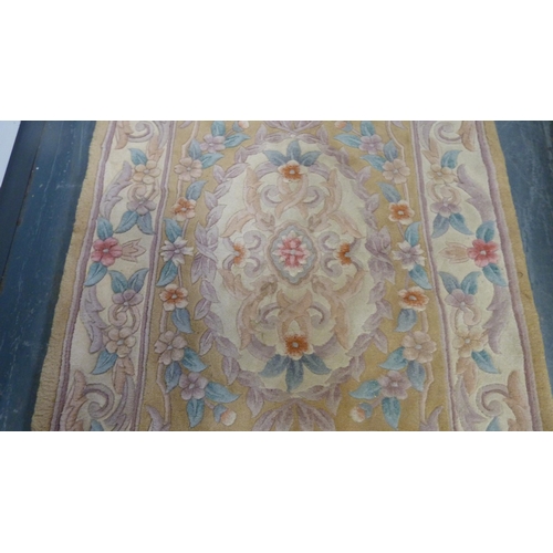 415 - Chinese-style rug on beige ground.