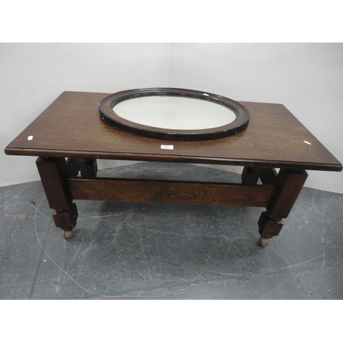 443 - Oak coffee table on castors and an oval wall mirror.  (2)