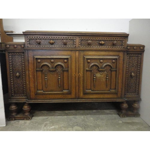 554 - Carved oak two-door sideboard raised on bulbous supports.