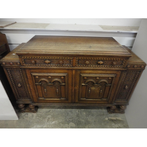 554 - Carved oak two-door sideboard raised on bulbous supports.