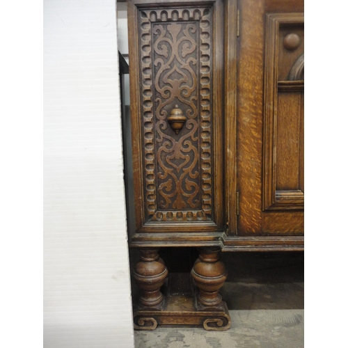 554 - Carved oak two-door sideboard raised on bulbous supports.