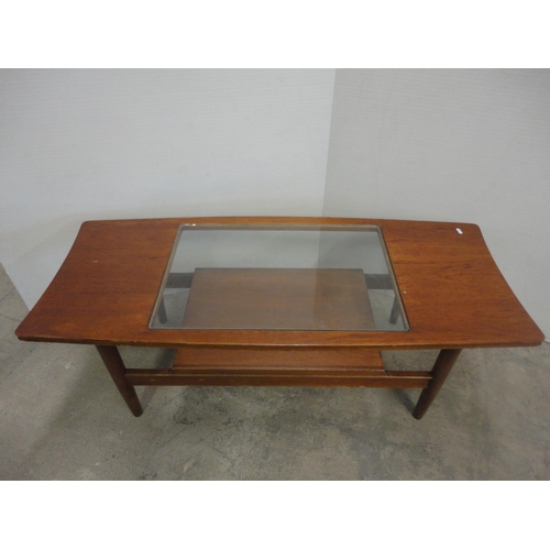 560 - Teak coffee table with glass top.