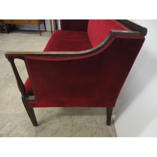 562 - Edwardian sofa upholstered in red velour, on square fluted supports.