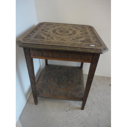 582 - Indian style carved two tier occasional table.