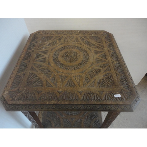 582 - Indian style carved two tier occasional table.