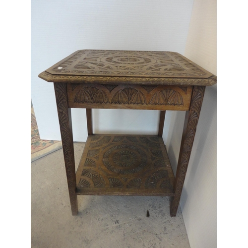 582 - Indian style carved two tier occasional table.