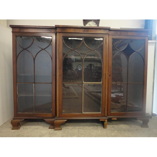 584 - Mahogany breakfront three-door bookcase enclosed by astragal glazed doors.