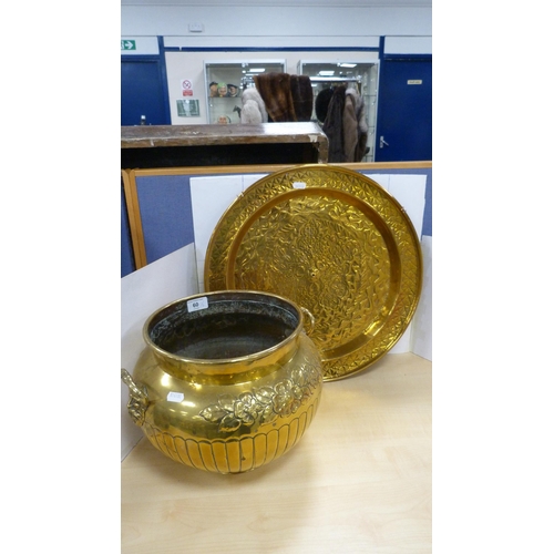 60 - Brass jardinière with mask handles and impressed with foliage, and a brass wall charger.  (2)