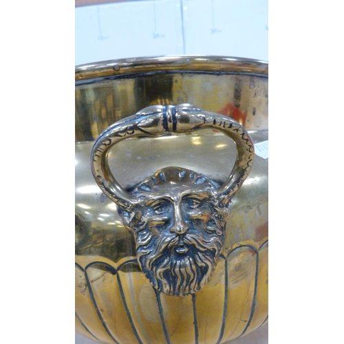 60 - Brass jardinière with mask handles and impressed with foliage, and a brass wall charger.  (2)