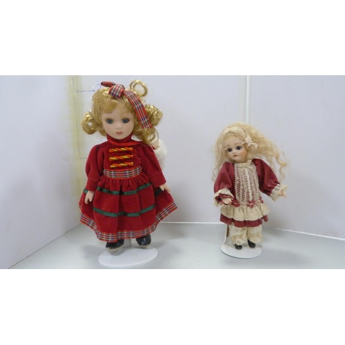 83 - Four bisque china dolls, in assorted dress.  (4)