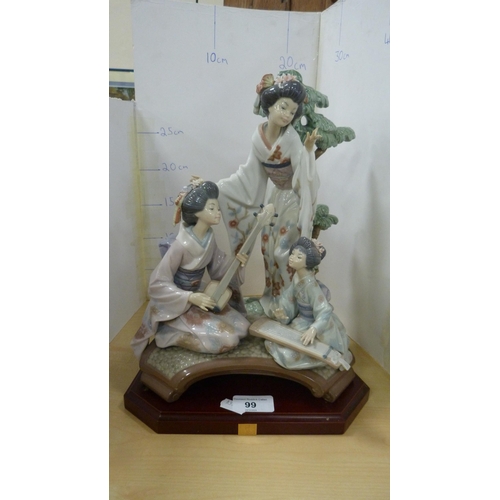 99 - Lladro group decorated by V Navarra, in the form of three Geisha playing instruments, with stand.