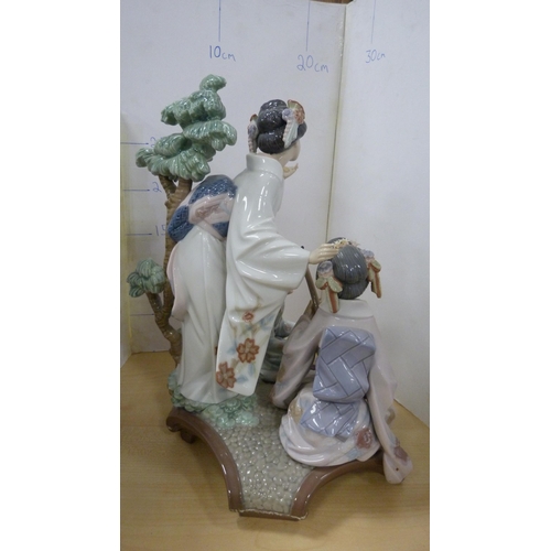 99 - Lladro group decorated by V Navarra, in the form of three Geisha playing instruments, with stand.