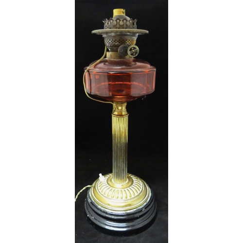 388 - Duplex oil lamp, c. early 20th century, with cranberry glass reservoir, above brass fluted cylindric... 