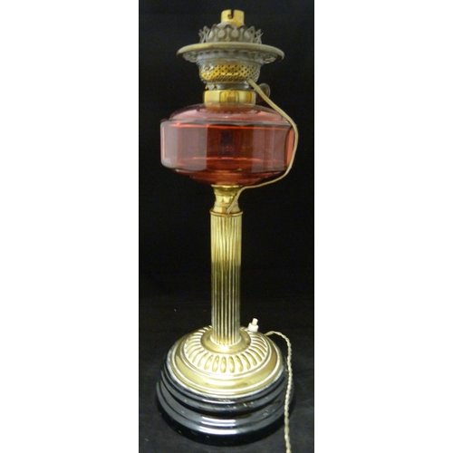 388 - Duplex oil lamp, c. early 20th century, with cranberry glass reservoir, above brass fluted cylindric... 