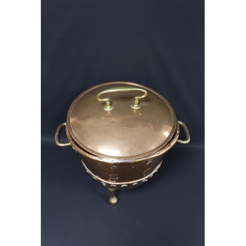 279 - Arts and Crafts twin handled lidded copper coal bin of banded and riveted construction, raised on tr... 