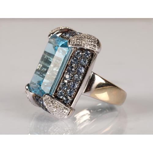 90 - 18K white gold cocktail ring set with a large pale blue gem, surrounded by smaller blue gems and dia... 