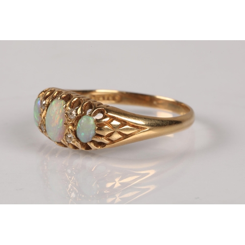 96 - 18ct gold ring set with trilogy of opals, interspersed with four small diamonds, 3.5g, ring size R