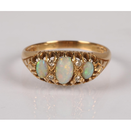 96 - 18ct gold ring set with trilogy of opals, interspersed with four small diamonds, 3.5g, ring size R