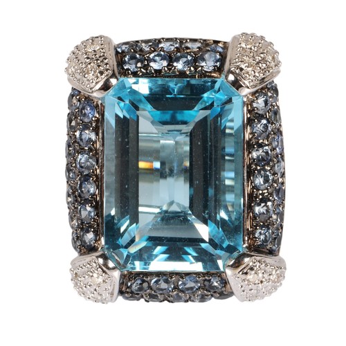 90 - 18K white gold cocktail ring set with a large pale blue gem, surrounded by smaller blue gems and dia... 