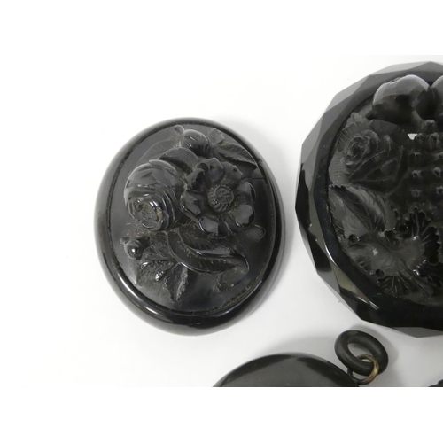 116 - Two jet brooches, another ebonite, another bog oak and a similar locket.