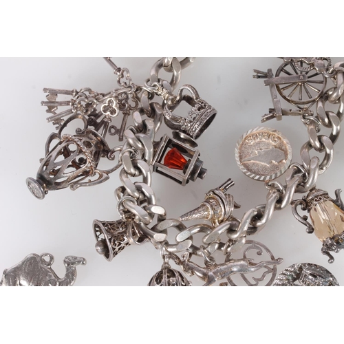 655 - Silver curb link charm bracelet and various charms, 92g gross.