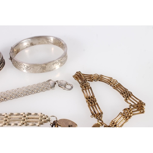 698 - Three silver bangles, a silver flex bracelet, two silver gate bracelets and a silver gilt gate brace... 