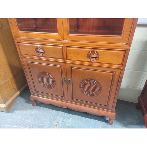 444 - 20th century Chinese rosewood display cabinet with carved dragon pediment, the twin glazed doors ope... 