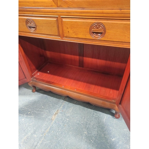 444 - 20th century Chinese rosewood display cabinet with carved dragon pediment, the twin glazed doors ope... 