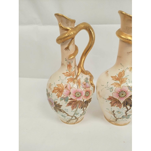 205 - Pair of Bonn ivory ground floral decorated jugs with stylised salamander handles. Height 30cm. 