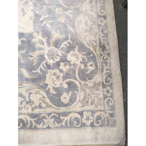 396 - Chinese style muted silk and wool carpet with central white floral panel encircled by a blue and bro... 