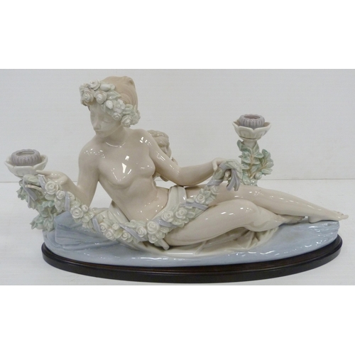 322 - Lladro candelabra modelled as a classical reclining nude female with crouching child behind, holding... 