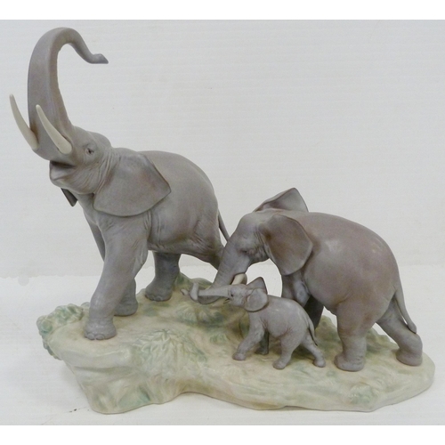 324 - Lladro matt glazed elephant group modelled as a male, female and baby elephant on naturalistic setti... 