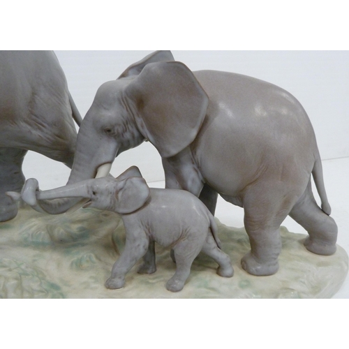 324 - Lladro matt glazed elephant group modelled as a male, female and baby elephant on naturalistic setti... 