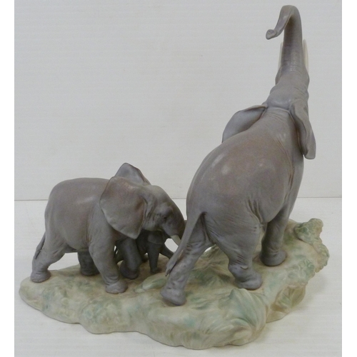 324 - Lladro matt glazed elephant group modelled as a male, female and baby elephant on naturalistic setti... 