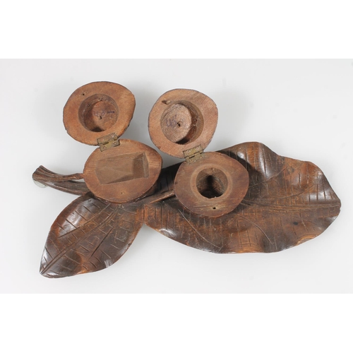 251 - Black Forest type carved treen inkwell of nut and leaf form, L26cm.