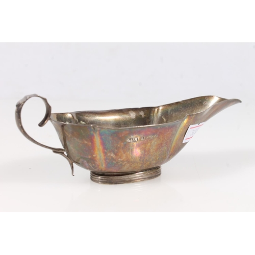 255 - Silver handled shoehorn and a small hallmarked silver sauce boat.