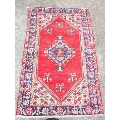 922 - Oriental cream ground and red geometric rug, 202cm x 131cm.