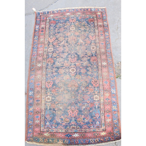 935 - Persian blue ground and red rug with floral motifs, 188cm x 109cm.