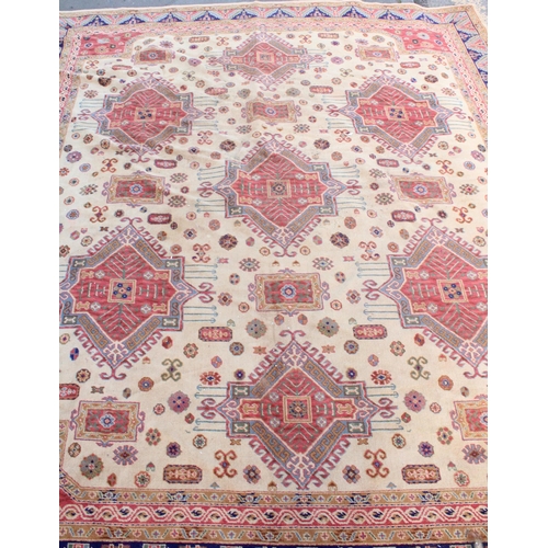 940 - Large Afghan Kazak carpet with polychrome geometric designs on a cream ground, 350cm x 310cm.