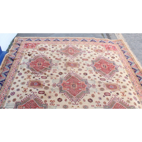 940 - Large Afghan Kazak carpet with polychrome geometric designs on a cream ground, 350cm x 310cm.