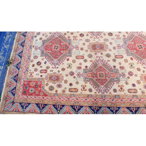 940 - Large Afghan Kazak carpet with polychrome geometric designs on a cream ground, 350cm x 310cm.