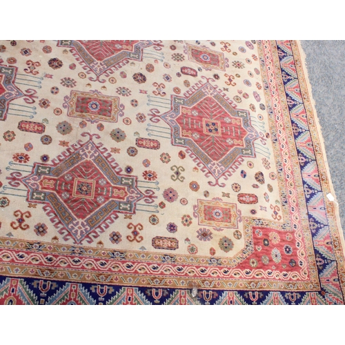 940 - Large Afghan Kazak carpet with polychrome geometric designs on a cream ground, 350cm x 310cm.