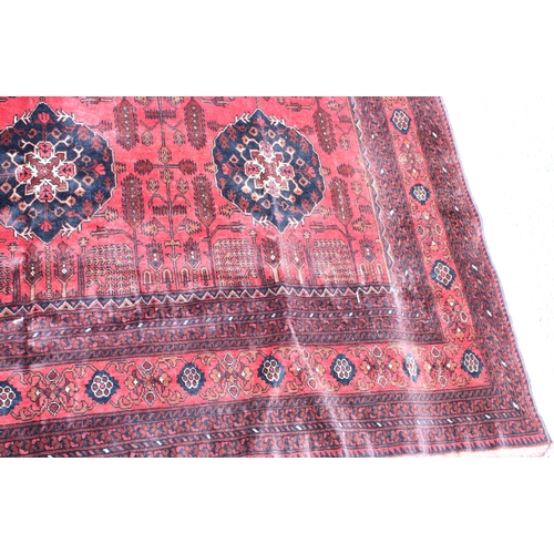 942 - Large Afghan tribal carpet with blue floral lozenges on a red ground, 370cm x 285cm.