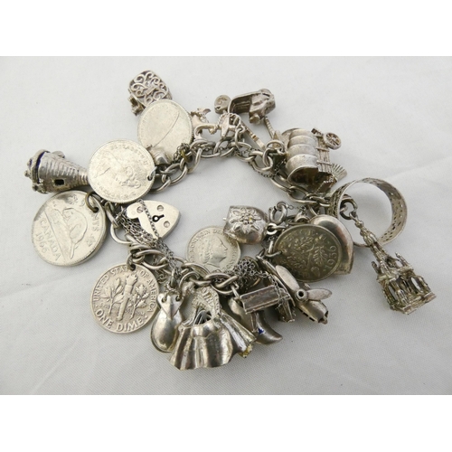 35 - Silver and nickel charm bracelet bearing assorted charms and attached coin pendants, some pendants m... 